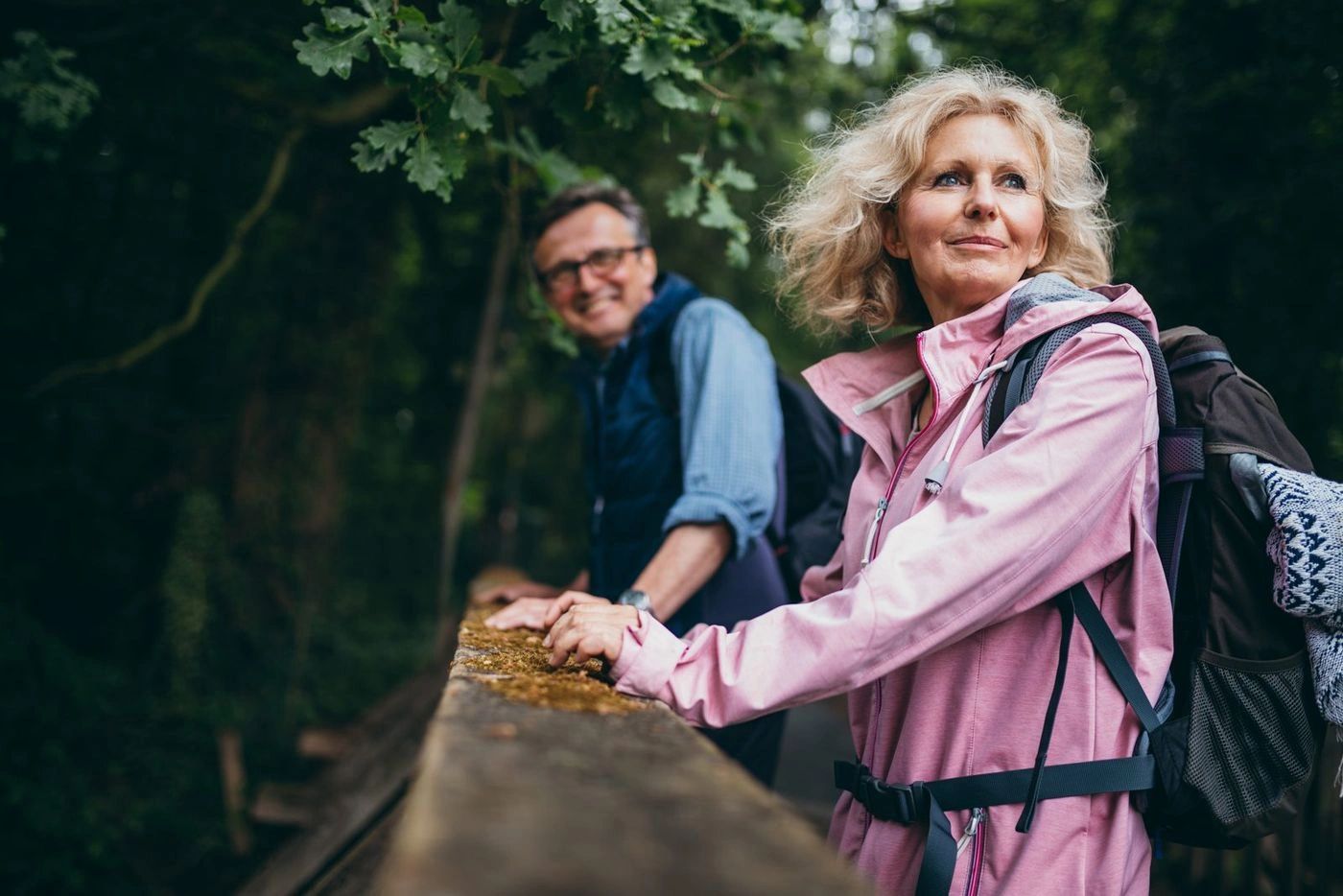 Two people pausing together on a wooded trail